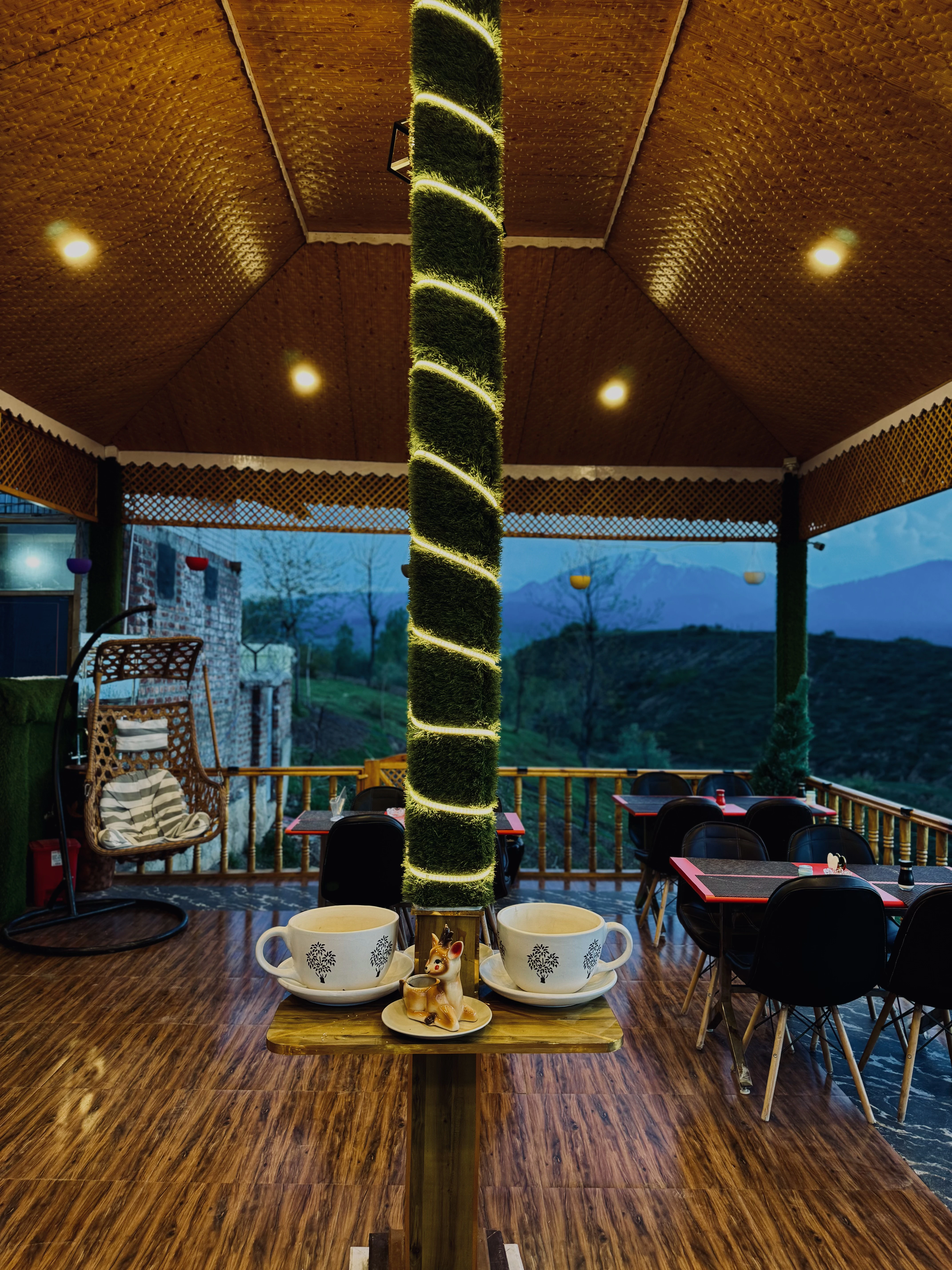 Luxury treehouse private reading lounge with large panoramic glass looking over Kashmir mountain ranges